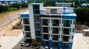 un bâtiment bleu et blanc avec des voitures garées devant dans l'établissement The Viewpoint Hotel, à Ban Wat Tha Maprang