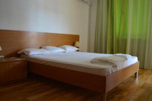 a bed in a room with a white bedspread at Arcadia Apart Complex in Sunny Beach
