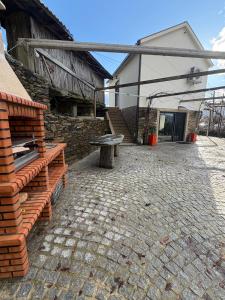 een stenen patio met een bank voor een gebouw bij Quinta do Passal in Parada de Ester