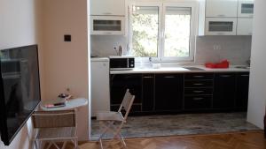 a kitchen with black cabinets and a table and a window at Apartment Lucky Lu in Bar