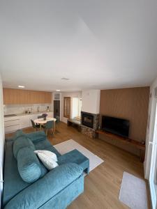 een woonkamer met een blauwe bank en een keuken bij Quinta do Passal in Parada de Ester