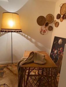 eine Lampe und ein Tisch mit einer Decke darauf in der Unterkunft La source, maison de ville vieux Périgueux in Périgueux
