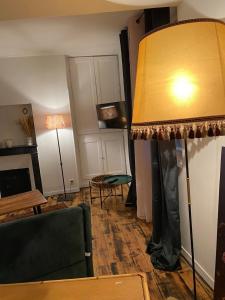 ein Wohnzimmer mit einem grünen Sofa und einer Lampe in der Unterkunft La source, maison de ville vieux Périgueux in Périgueux