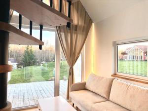 a living room with a couch and a large window at Namelis su sauna SMILGA in Radailiai