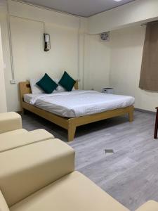 a bedroom with a large bed with green pillows at Uncle Yo House in Ban Tha Khreng