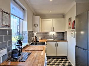 a kitchen with white cabinets and a stainless steel refrigerator at 2 Bed in Penzance oc-m27232 in Gulval