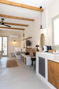 a white room with a kitchen and a bedroom at Althea Anafi Suites in Anafi