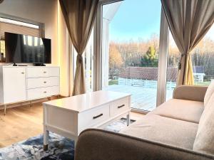a living room with a couch and a tv and a window at Namelis su sauna SMILGA in Radailiai