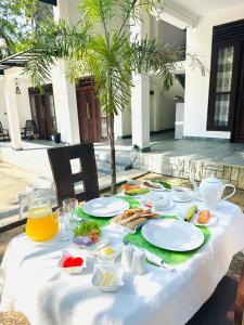 een tafel met daarop borden met eten bij Ibeeza Motel - Bathigama in Dikwella