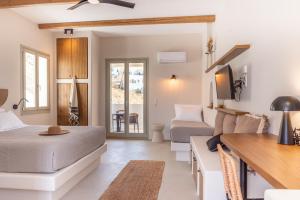 a bedroom with a bed and a couch and a tv at Althea Anafi Suites in Anafi +68 photos