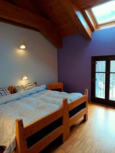 een slaapkamer met een groot houten bed met blauwe muren bij Rifugio Alevé in Castello