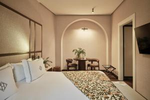 a hotel room with a bed and a table at Hospes Palacio del Bailio, a Member of Design Hotels in Córdoba