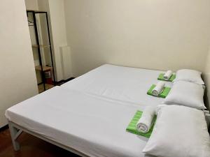 a white bed with towels on it in a room at Mybed Dormitory in Cebu City