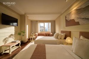 een hotelkamer met twee bedden en een televisie bij Silverland Jolie Hotel in Ho Chi Minh-stad