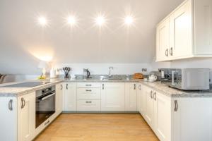 a kitchen with white cabinets and a wooden floor at 2 Bed in Duddlestone oc-q34588 in Duddlestone +27 photos