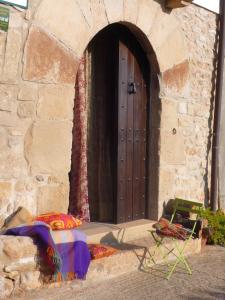 a door to a building with a table and a chair at Casa La Rinconada in Azuelo
