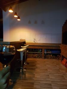 een persoon die een glas wijn vasthoudt in een keuken bij Sophia's Corner in Cambuí