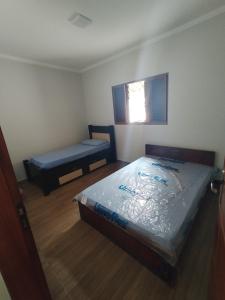 een kleine kamer met een bed en een bank bij Sophia's Corner in Cambuí