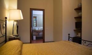a bedroom with a bed and a door leading to a bathroom at Golf Club Bellosguardo resort in Vinci