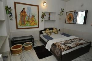 焦特布尔L G Guest House的一间卧室，墙上有两张床和一幅画