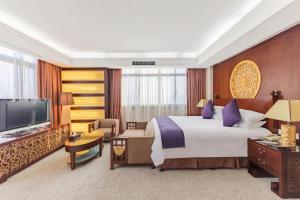 a hotel room with a bed and a television at Dajiuhua Hotel in Chizhou