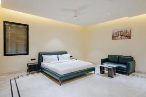 a bedroom with a bed and a couch and a chair at CS Luxurio Presendential Suites Gachibowli in Hyderabad +40 photos