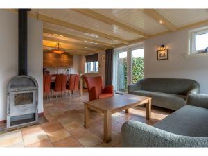 een woonkamer met een bank, een tafel en een fornuis bij Lovely Holiday Home in Texel near Sea in Oost
