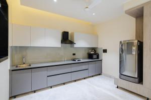 a kitchen with white cabinets and a stainless steel refrigerator at CS Luxurio Presendential Suites Gachibowli in Hyderabad