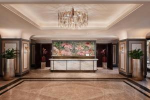 een lobby met een groot schilderij aan de muur en een kroonluchter bij Renaissance Goa Hotel in Goa +48 foto's