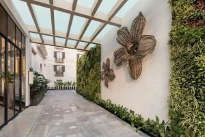 een wandelpad met vlinders op de muur van een gebouw bij Renaissance Goa Hotel in Goa