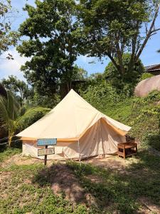 a large tent with a table in a field at The Lighthouse - Eco-Village & Wellness in Koh Tao