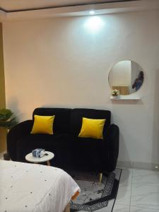 アビジャンにあるAKAWABA Residenceのリビングルーム(黒いソファ、鏡付) +1枚の写真