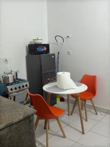 アビジャンにあるAKAWABA Residenceの椅子2脚と帽子が置かれたテーブルのあるキッチン