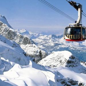 een skilift die over een met sneeuw bedekte berg vliegt bij Titlis Studio Engelberg with Balcony great View in Engelberg