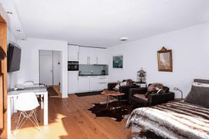 a living room with a bed and a couch and a kitchen at Titlis Studio Engelberg with Balcony great View in Engelberg