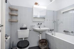 a bathroom with a toilet and a sink and a bath tub at Titlis Studio Engelberg with Balcony great View in Engelberg
