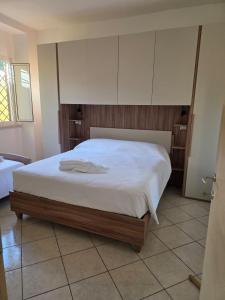 una camera da letto con letto con lenzuola e armadi bianchi di Aurora Residence a Roma