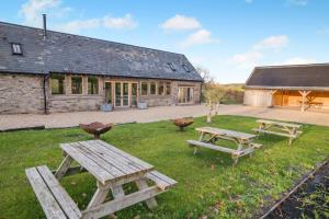 a yard with picnic tables and a building at 3 Bed in Dulas oc-g34082 in Longtown
