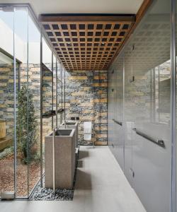 un bagno con quattro lavandini e un muro di pietra di Voyage Torba Hotel a Torba