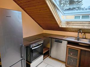 a small kitchen with a sink and a stove at Hostel Fantasy in Gröbenzell +4 photos