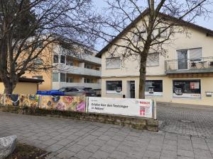 a white building with a sign in front of it at Hostel Fantasy in Gröbenzell
