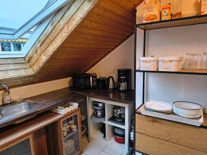 a kitchen with a sink and an open refrigerator at Hostel Fantasy in Gröbenzell