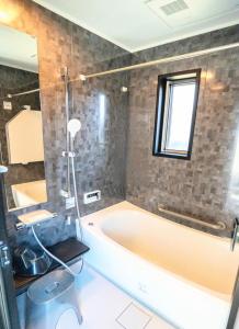 een badkamer met een ligbad en een wastafel bij BASE 1901 - Vacation STAY 88754v in Minamiboso