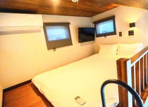 een kleine slaapkamer met een bed en twee ramen bij BASE 1901 - Vacation STAY 88754v in Minamiboso
