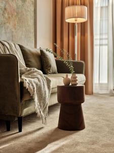 een woonkamer met een bank en een tafel bij Arche Hotel Puławska Residence Warszawa in Warschau