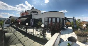 ein Gebäude mit einem Restaurant auf dem Dach in der Unterkunft Skycity Hotel Atrigon in Klagenfurt am Wörthersee