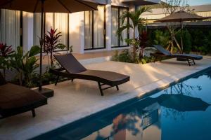 een zwembad met twee stoelen en een parasol bij Sinapa Suites in Ko Pha Ngan +18 foto's