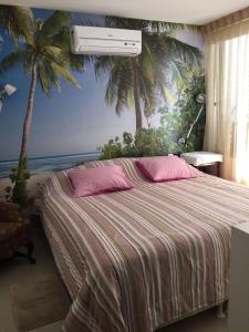 a bedroom with a bed with palm trees on the wall at Extraordinary Seafront Apartment in Recife