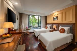 een hotelkamer met twee bedden en een bureau bij Hanoi Pearl Hotel in Hanoi
