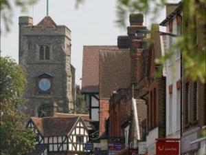 a building with a clock tower in a city at Costa del Pinner in Northwood